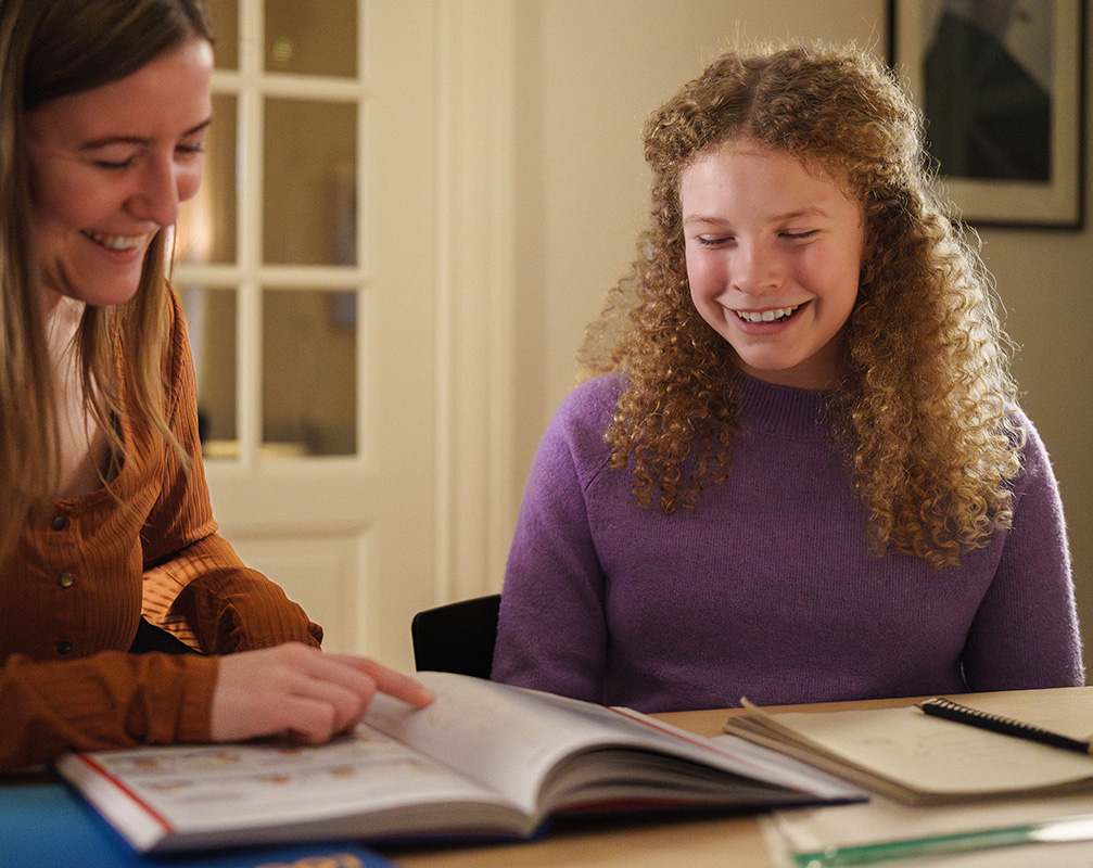 Underviser og elev har det moro med undervisningen